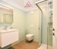 Bathroom with shower, toilet, sink, mirror, light fixtures