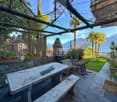 outdoor dining table with a bench, stone wall, plants and mountain view