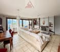 living room with sofa, coffee table, TV, fireplace, dining table, chairs, glass doors, lake view