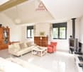 white couch, wooden cabinet, TV, red chair, coffee table, fireplace