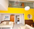 modern living room with yellow wall, white leather sofas, piano, wooden cabinet, bookshelf, lamps, table with lamp