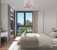 bedroom with double bed, wooden floor, large window with city view, hanging lamps, built-in wardrobe, decorative objects