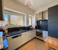 modern kitchen with granite countertops, white cabinets, integrated appliances, stainless steel fixtures