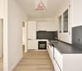 modern kitchen with white cabinets, black countertop, dishwasher, oven, sink, and faucet