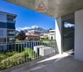 Outdoor balcony with metal railings, tiled floor, and views of the surrounding area