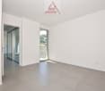 empty room with sliding glass doors, white walls, tiled floor, visible balcony