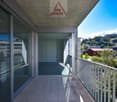 large balcony with full glass walls, metal railing, open to a hallway