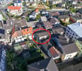 House surrounded by other houses in a neighborhood with solar panels on some roofs.