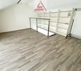large room, wooden floor, white walls, large glass railing, tall white shelf