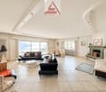 modern and large living room, 3 couches, coffee table, fireplace, view of the mountains, large windows