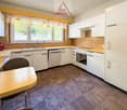 White cabinetry, yellow countertops, modern appliances, including a dishwasher, and a sink with a faucet.