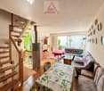 living room, dining table, floral table cover, sofa, armchairs, large windows, wooden stairs, radiator, fireplace, wooden floor, wooden cabinets