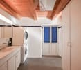 White cabinets, countertop, sink, and a washer dryer