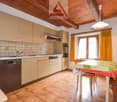 modern kitchen with tile flooring, cabinets, dishwasher, sink, oven, window, table, chairs, lamp