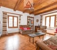 exposed wooden ceiling, Fireplace, tile floor, sofa, coffee table, television, bookshelf, chairs, bookshelves, window