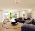 modern style, blue sectional sofa, round coffee table, large round rug, white armchair, beige curtains, plants, ocean view