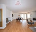 Fireplace, hardwood floor, large windows, dining area, glass door, table and chairs, television, rocking chair, couch, rug, table