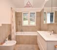 Bathtub, shower, sink, mirror, wooden countertop, tile floor, natural light