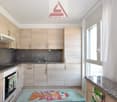 modern kitchen with wooden cabinets, granite countertops, integrated dishwasher, gas stove, sink, faucet, and a window
