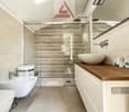 modern bathroom with shower, sink, toilet, and vanity