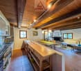 kitchen with dining area, fireplace, living room with couch, dining table, chairs, wooden beams, tiled floor