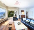 large windows, balcony, black leather sofa, white coffee table, decorative items, painting