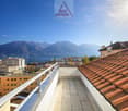 Balcony with tiled floor, metal railing, view of mountains and lake