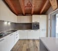modern kitchen with white cabinets, wooden floor, stainless steel appliances, large window