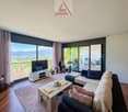 large windows, balcony, couch, coffee table, TV, carpet, wooden floor