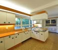 modern kitchen, white cabinets, wooden countertops, stainless steel appliances, tiled flooring, orange and white color scheme