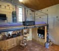 loft room with loft bed, desk, TV, cabinet, chair, radiator, flooring