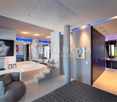 Spacious master bedroom with modern decor, large windows, jacuzzi tub, fireplace, and artwork on the walls