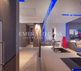 Modern office space with sleek kitchen counter, stainless steel appliances, and Emerald Casa Luxury Real Estate branding on the wall
