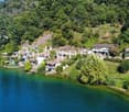 group of houses along the lake with beautiful views, each with its own dock, lush greenery surrounding the houses, terraced hillsides