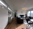 modern interior design, hardwood floors, large windows, fireplace, modern sofas, coffee table, dining table, radiators, picture frame, modern lamps, ceiling lights
