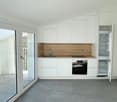 modern kitchen with white cabinetry, wooden countertop, sink, oven, fridge, tile flooring, sliding glass door