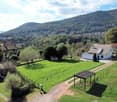 Rustic farmhouse with large plot, mountains in the background