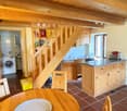 wooden cabinets, tiled floor, washing machine, dining table, chairs, wooden staircase