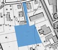 Plot of land with a blue shaded area indicating the property boundary, surrounded by other plots and streets.