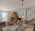 Dining table, chairs, staircase, living room couch, TV, fireplace
