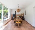 dining room with large windows, wooden table, chairs, fireplace, tiled floor, pendant lights