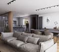 The image shows a modern, open-plan living space with a large, comfortable gray sofa, a dining area with a dark wooden table and chairs, and a kitchen area with sleek, gray cabinets and countertops. The room has large windows that provide natural light an