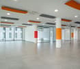modern open space, square tiles, orange and white pillars, large windows, air vents on ceiling