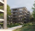 Multi-story apartment building with balconies and landscaped surroundings.