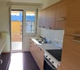 modern kitchen, wooden cabinets, double sink, oven, microwave, balcony, windows