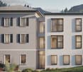 Modern white apartment building with windows, front garden with flowers, hilly mountain landscape in the background