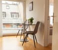 small dining area with two chairs, table, window with a view, potted plant, decorative items