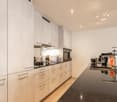 modern kitchen, granite countertops, stainless steel appliances, wooden floor, white cabinets, under cabinet lighting