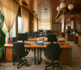 modern office with desks, monitors, plants, wooden cabinets, windows with curtains