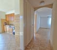 kitchen with wooden cabinets, tiled floor, sink, oven, balcony with glass door